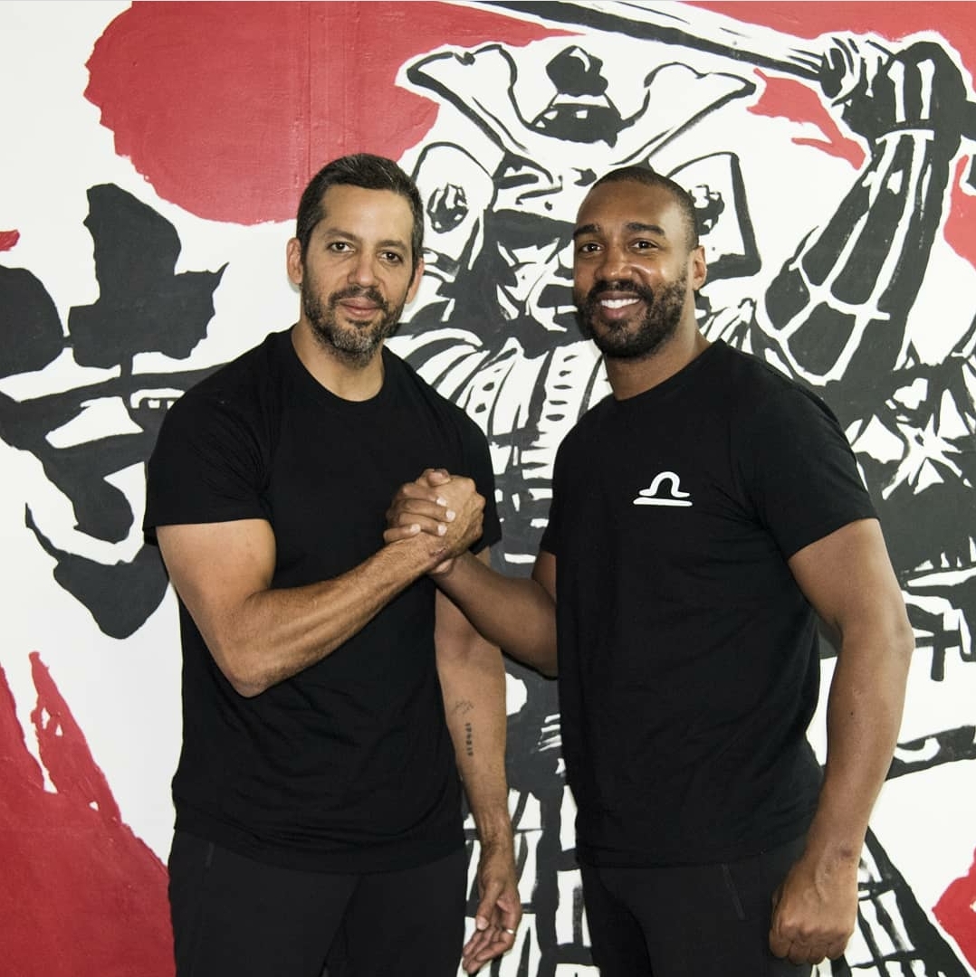 Abdoulaye Fadiga clasping hands in front of the samurai mural at Champion Spirit
